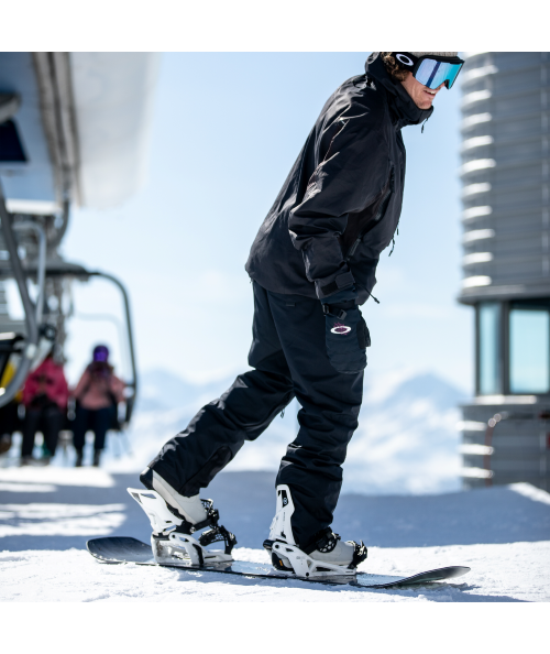 Snowboarder stepping into snowboard bindings